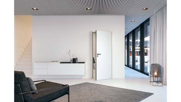 Modernes Wohnzimmer mit weißen Wänden, einer offenen weißen Tür, minimalistischer Dekoration und großen Fenstern, die auf einen Balkon führen